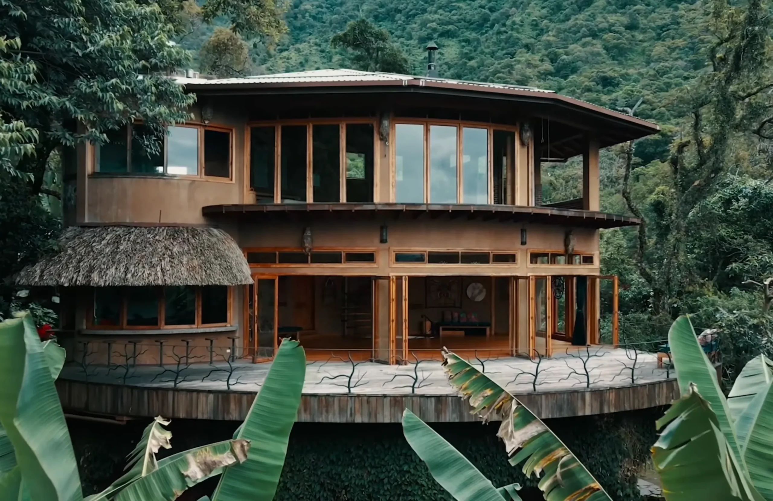 A round timber and thatch retreat house surrounded by jungle and banana leaves in San Marcos, Lake Atitlán
